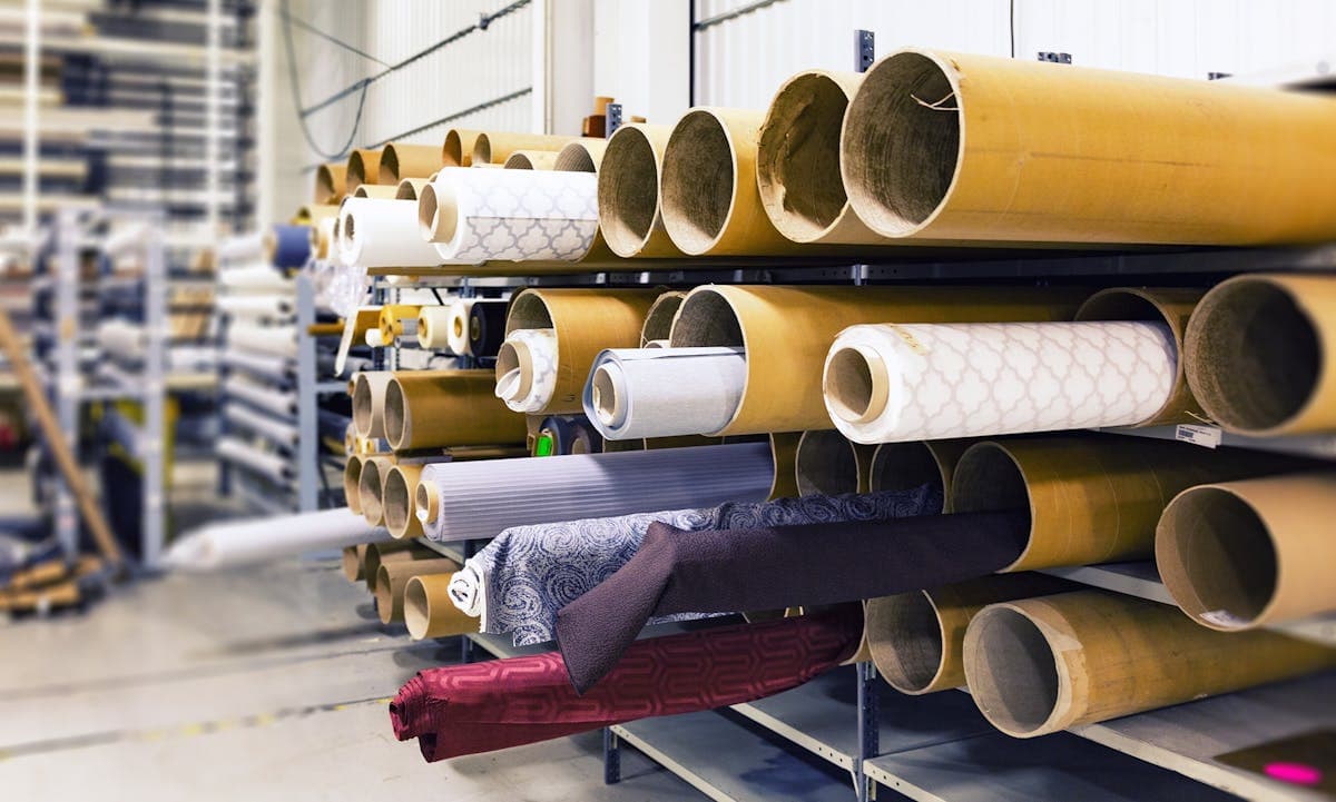 Rows of finished fabric rolls in factory